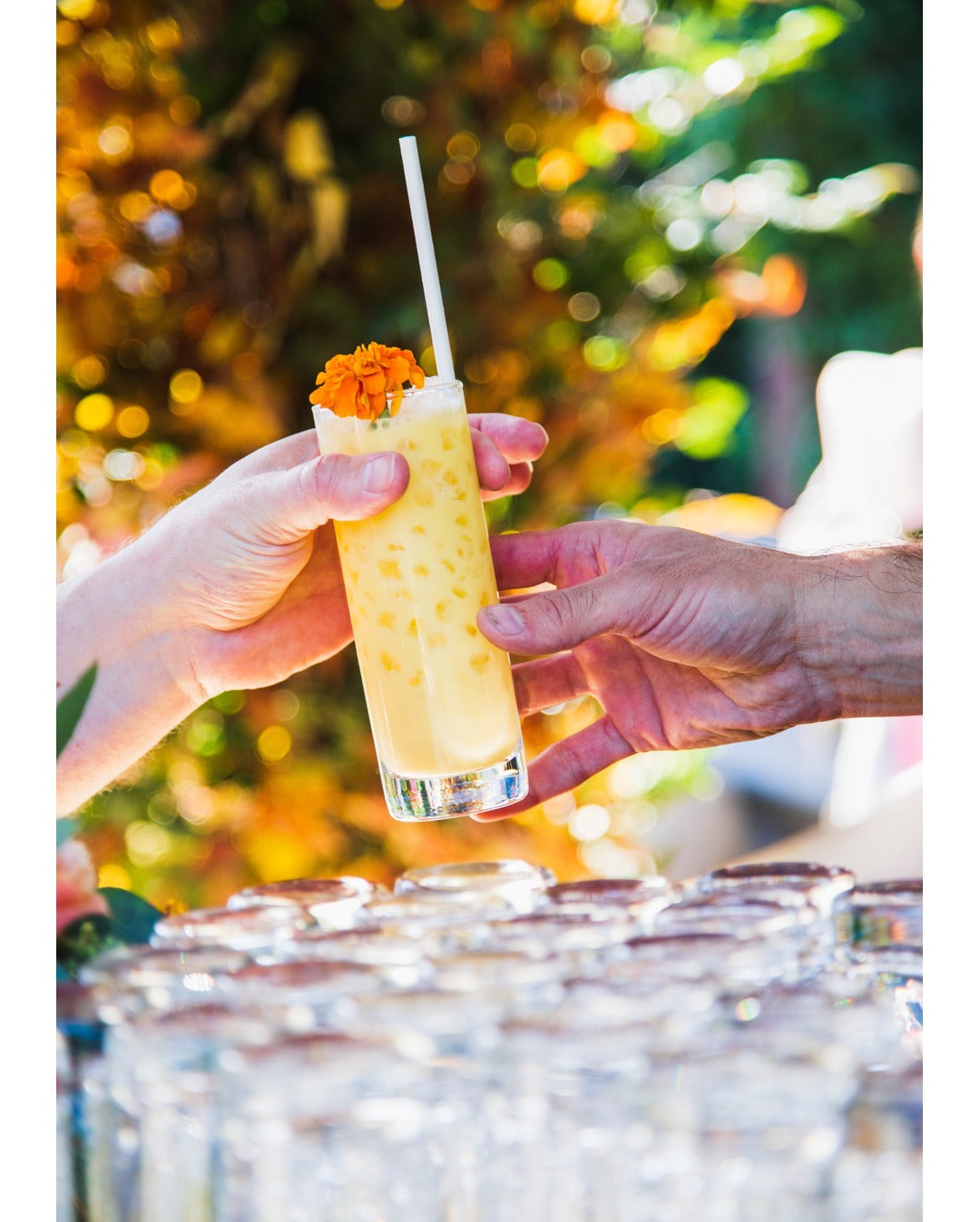 Cocktail drink being handed to a guest, from the craft mobile cocktail catering bar installation service.